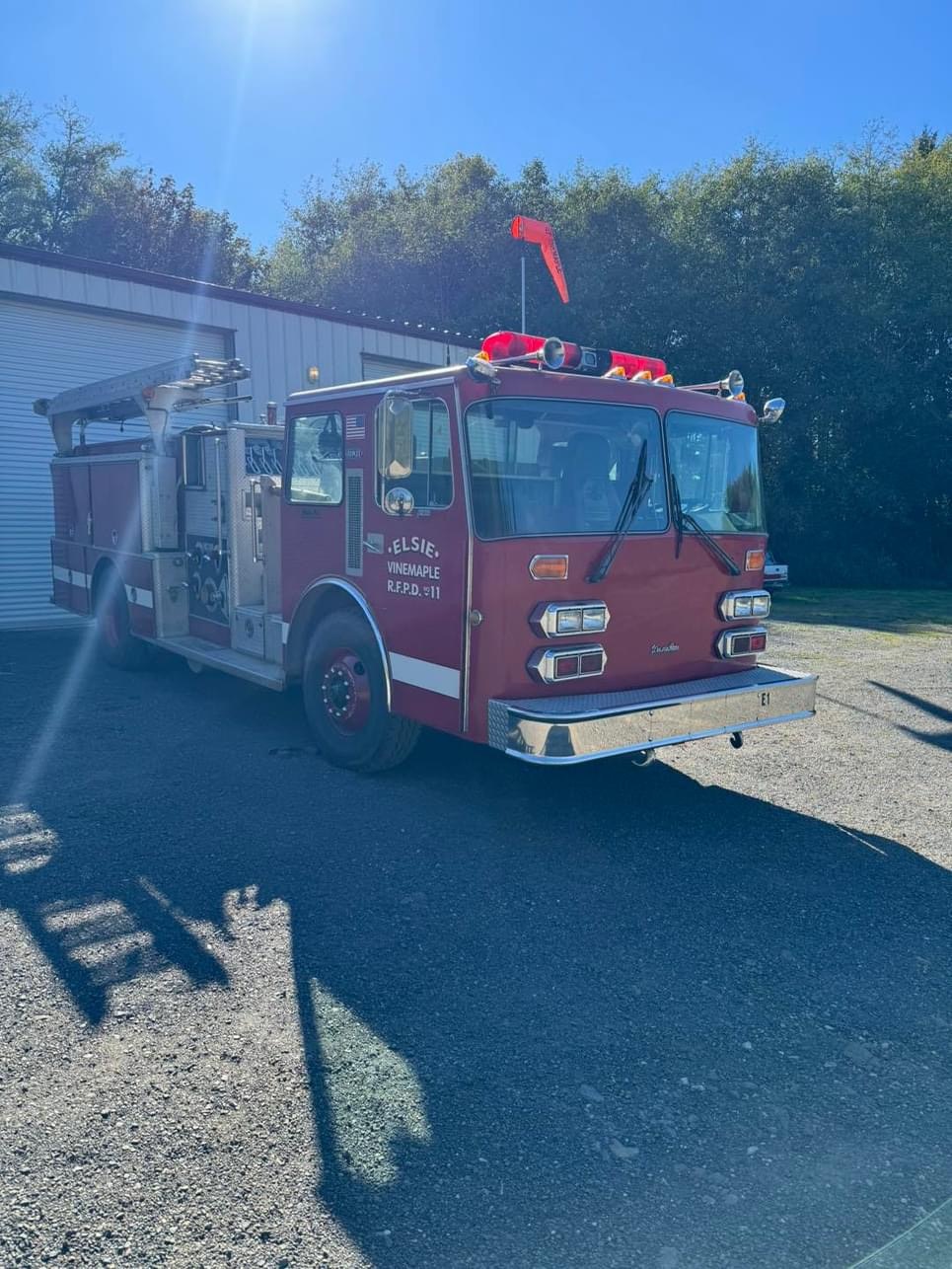 A red fire truck parked outside on a sunny day.