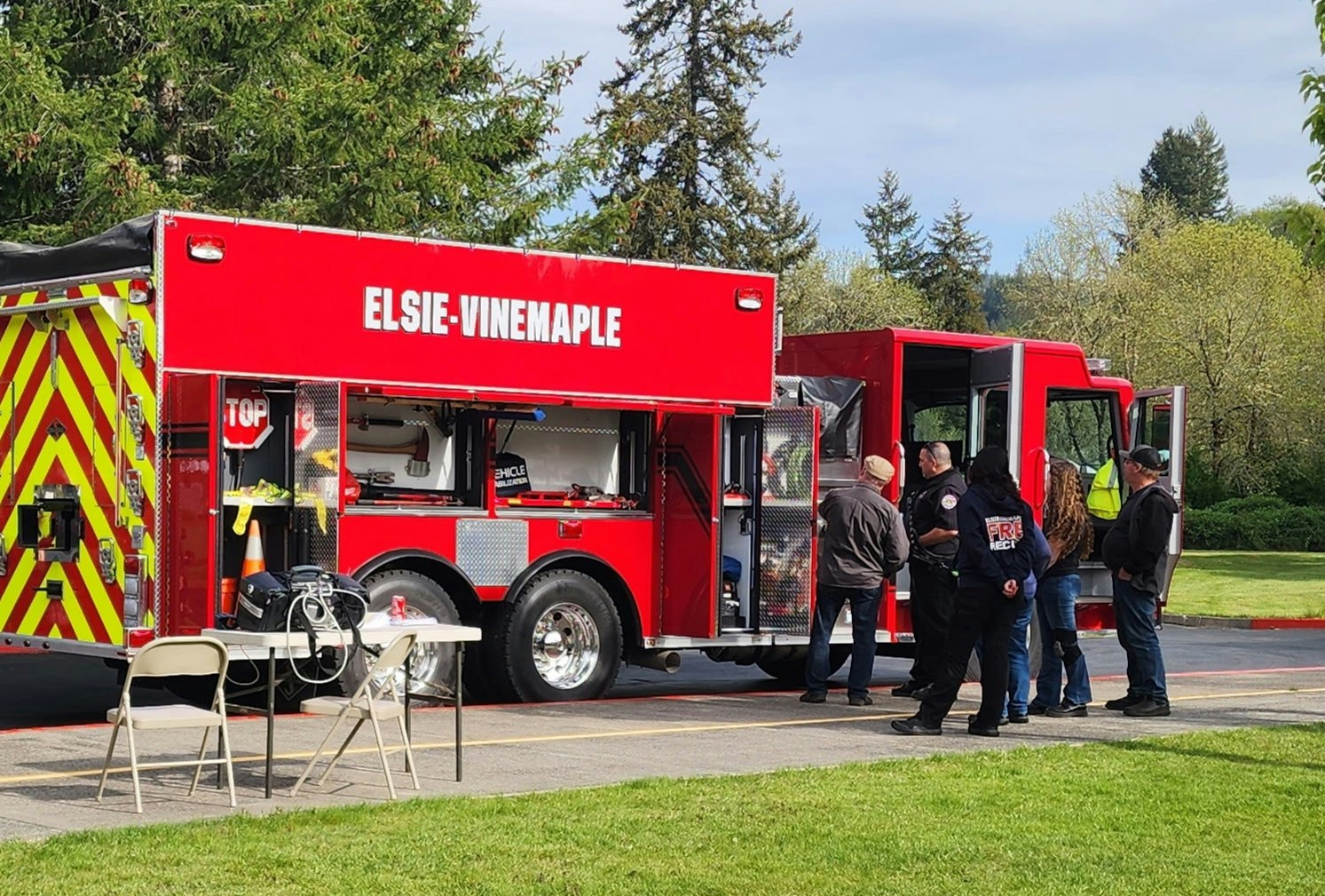 Red fire truck labeled "ELSIE-VINEMAPLE" with people gathered around it.