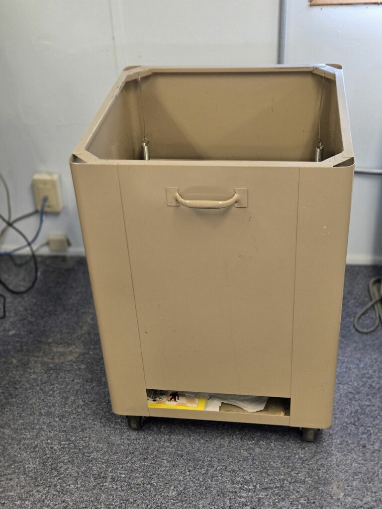 A beige, wheeled cart with an open top and a handle, likely used for storage or transportation of items.