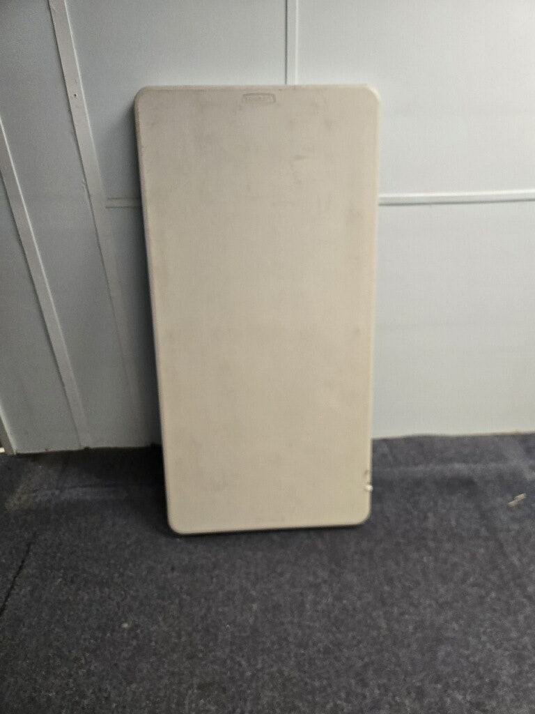 It's an upright, light-colored rectangular table, placed against a wall on a dark floor.