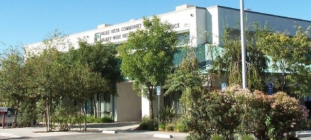 The image shows a building labeled "Valle Vista Community" surrounded by trees and landscaping, likely a public facility.