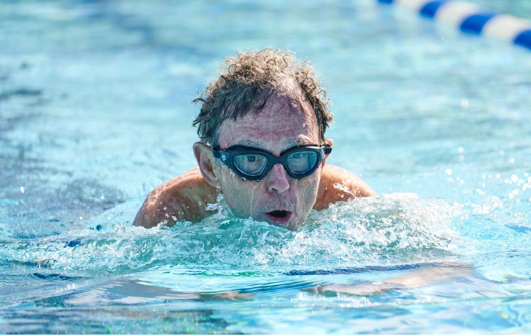 A person swimming with goggles in a pool.