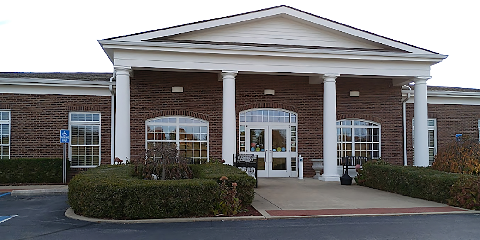 A brick building with a white columned entrance, possibly a public facility.