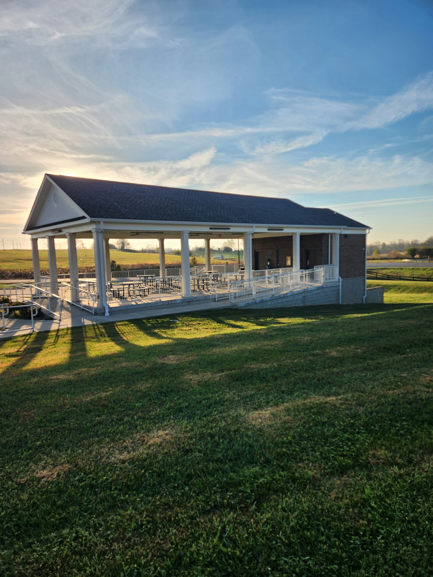 The Pavilion building on a grassy field with a clear sky