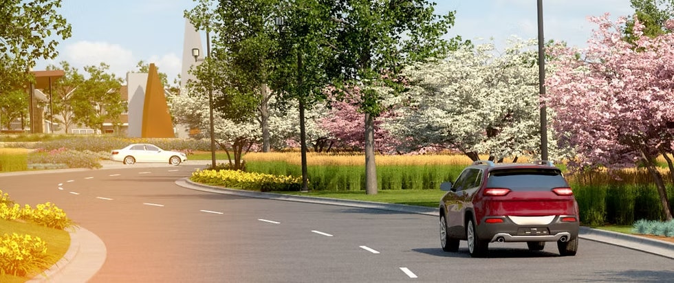 Two cars on a curved road surrounded by blooming trees and greenery.