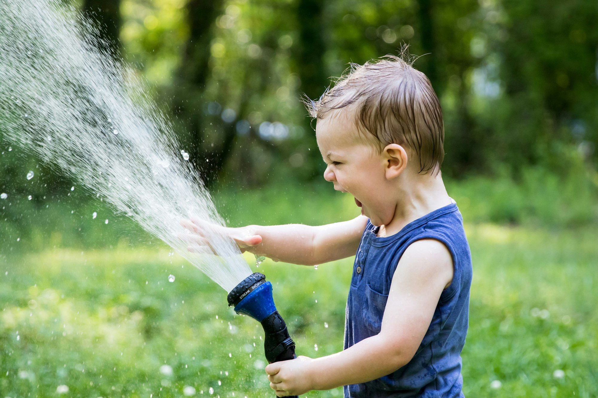 child spraying hose water