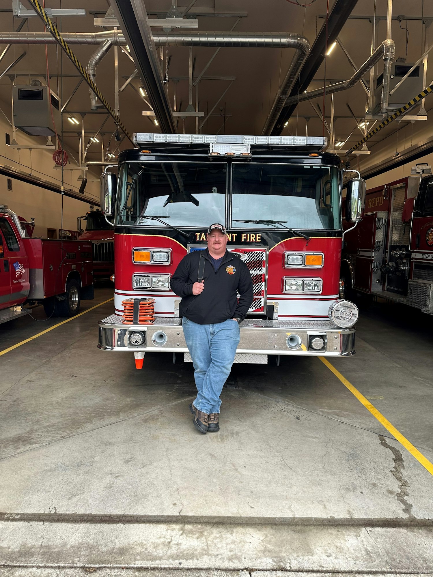 May contain: bumper, transportation, vehicle, adult, male, man, person, fire truck, truck, clothing, footwear, shoe, and hat