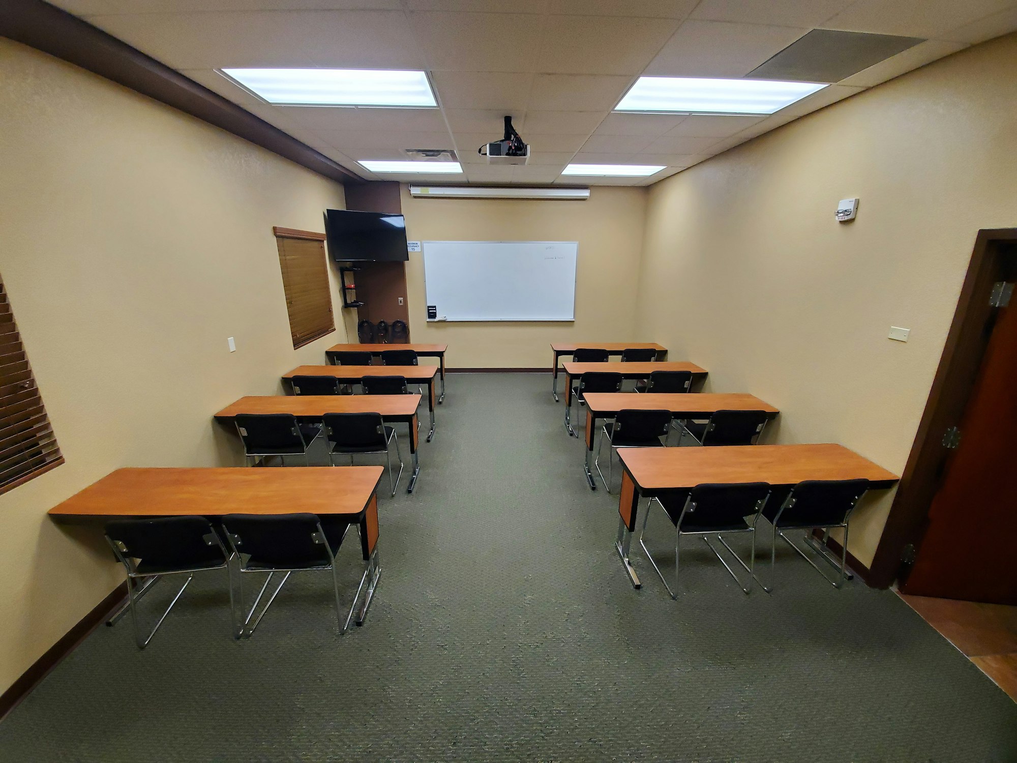 May contain: school, building, architecture, people, person, classroom, indoors, room, chair, furniture, desk, table, monitor, screen, hardware, electronics, and computer hardware
