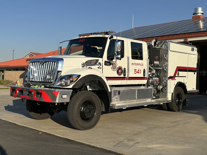 A white fire truck labeled 'INTERFACE 541' is parked outside, possibly at a fire station.