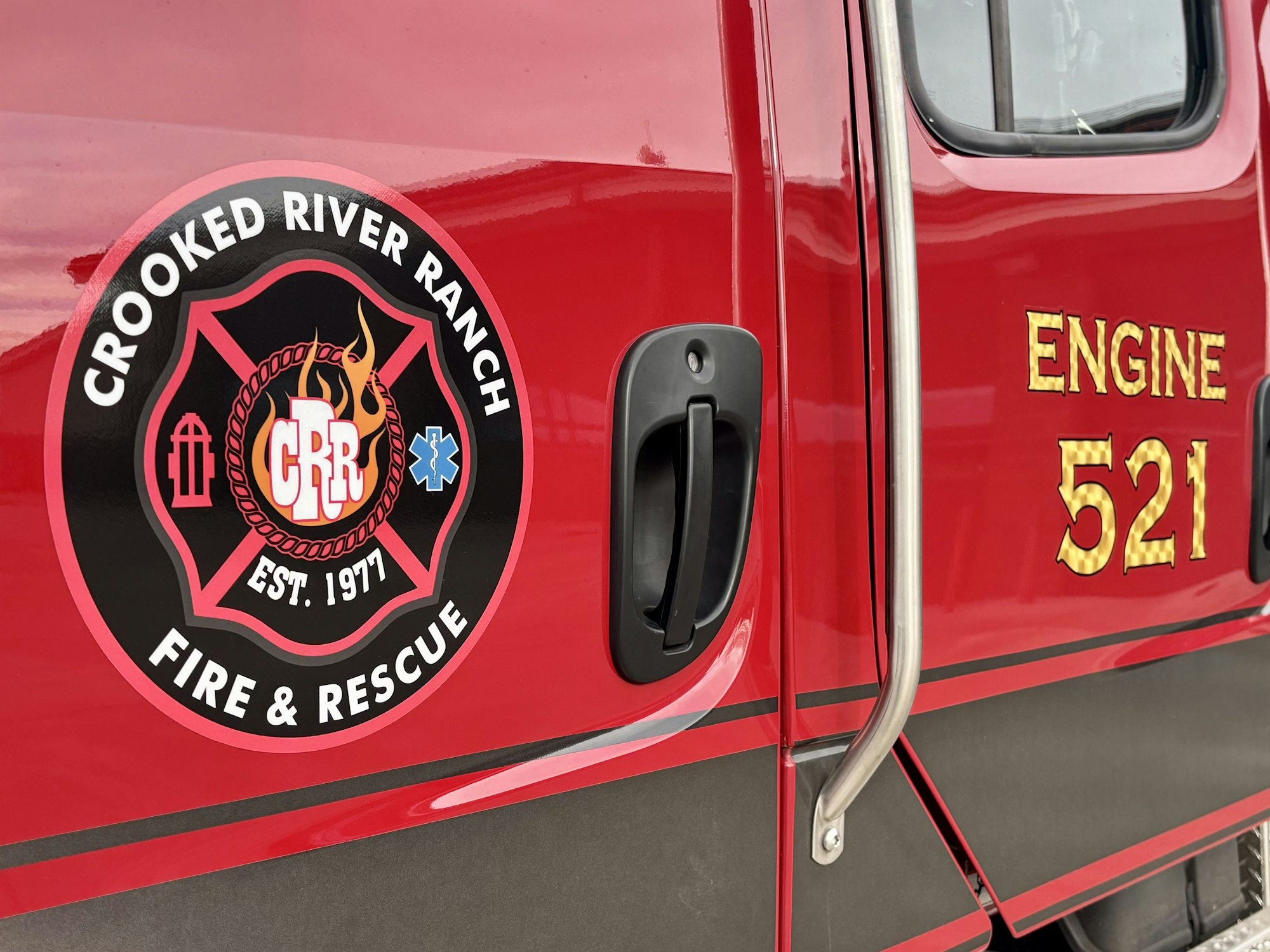 Fire truck door with "Crooked River Ranch Fire & Rescue" logo and "Engine 521" text.