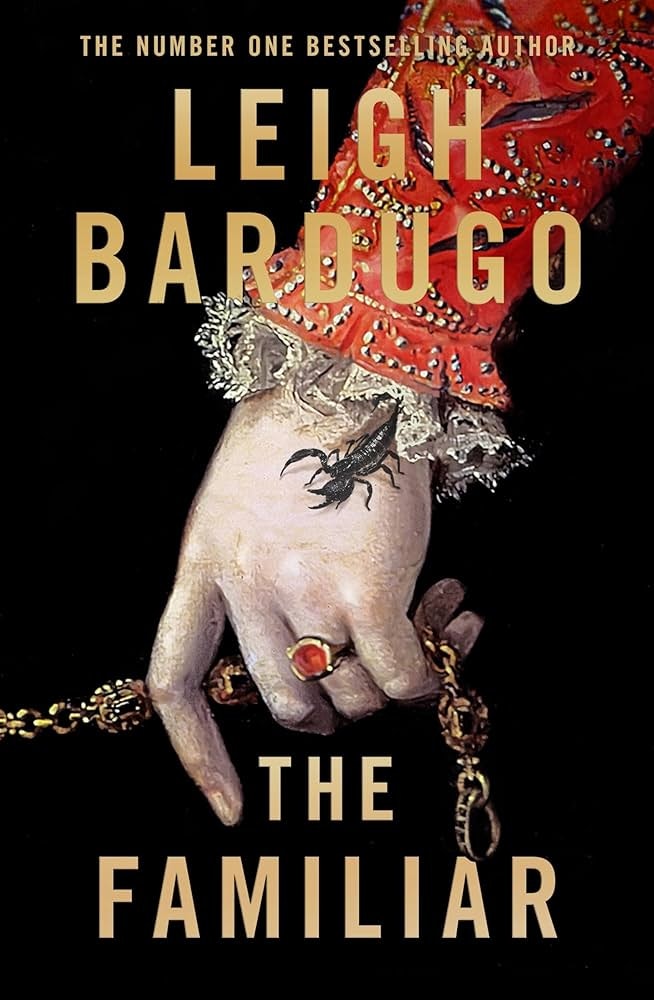 The image is the book cover for "The Familiar" by Leigh Bardugo, featuring a decorative hand with a scorpion.