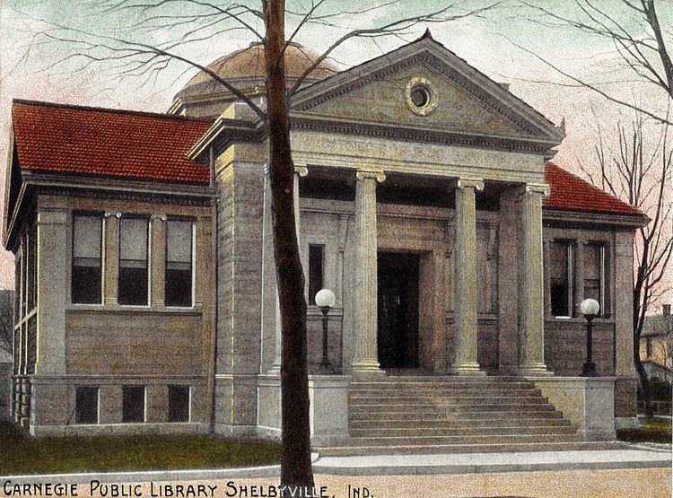 An old postcard of the Carnegie Public Library in Shelbyville, Indiana, with classical architecture and steps leading up to it.