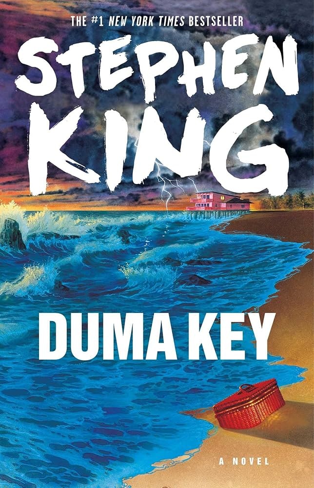 The image features the cover of "Duma Key," a novel by Stephen King, showcasing a stormy beach scene with a red basket.