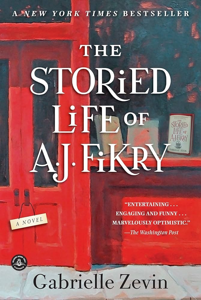 The image is the cover of "The Storied Life of A.J. Fikry," a bestselling novel by Gabrielle Zevin. It has a red background and reviews.