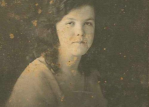 Aged photo of a woman with visible deterioration spots.