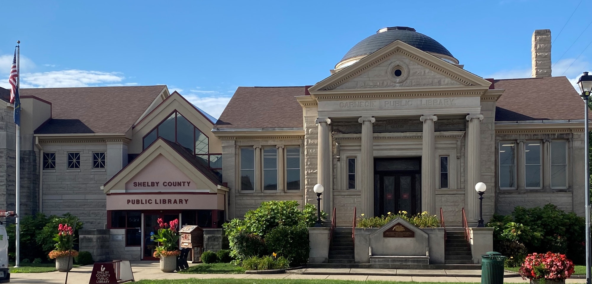 Shelby County Public Library with a classic facade, dome, and columns, against a blue sky.