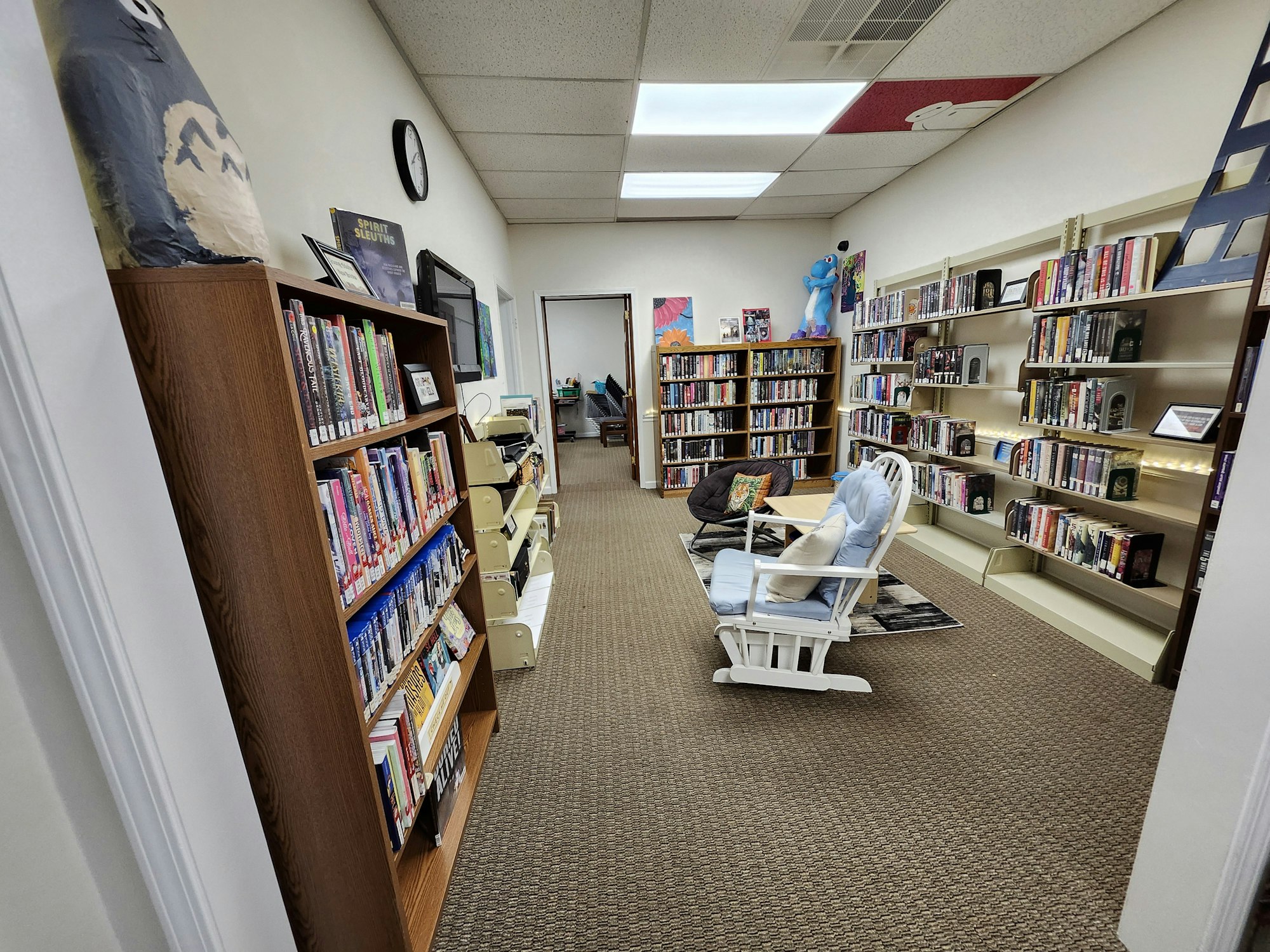 A cozy library with bookshelves, a rocking chair, and decorative items.