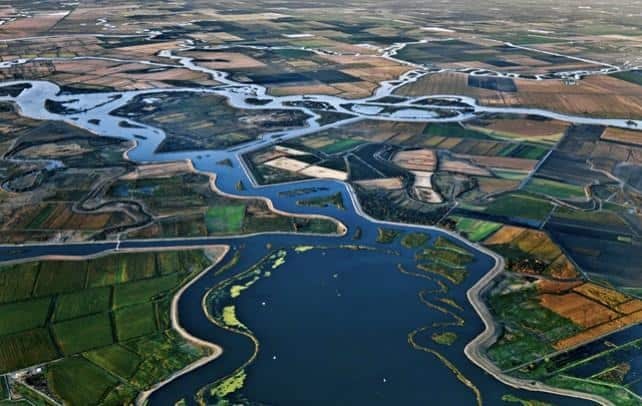 Aerial view of a waterbody with meandering rivers and cultivated land.