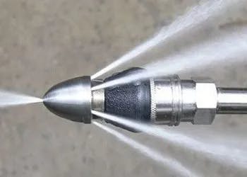 A fuel injector nozzle spraying liquid, demonstrating atomization.