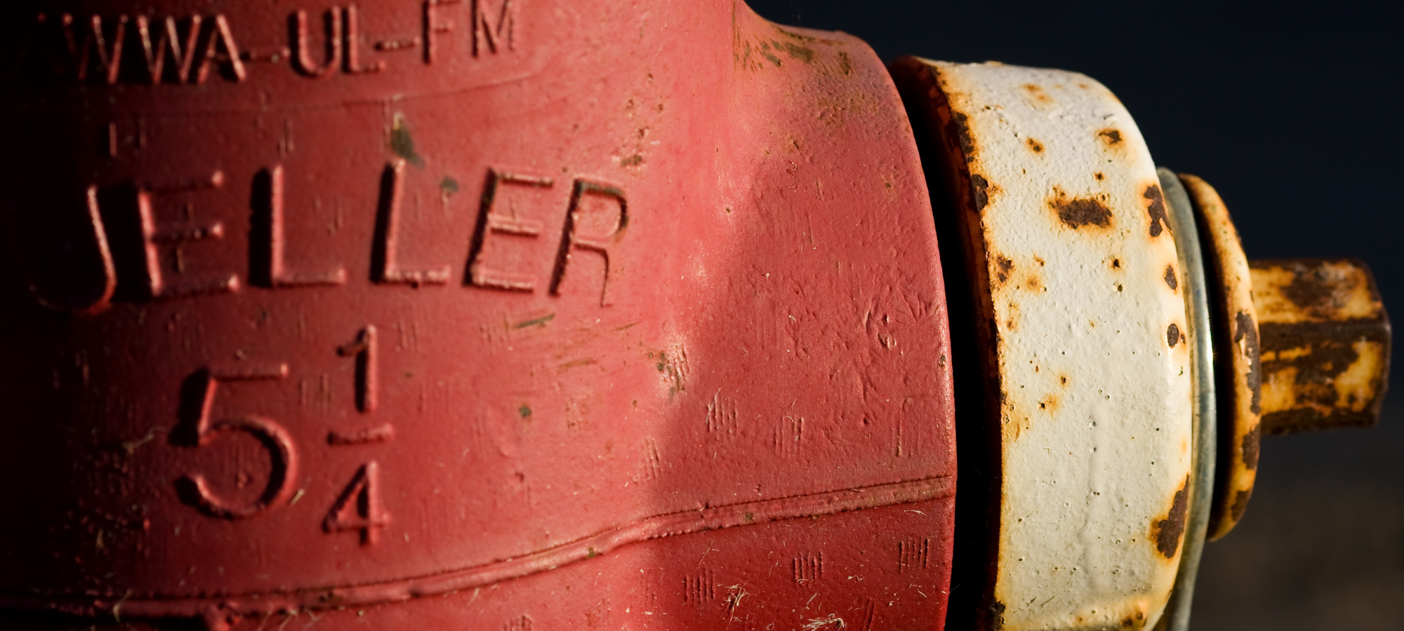 A close-up of a weathered red fire hydrant with visible rust and markings.