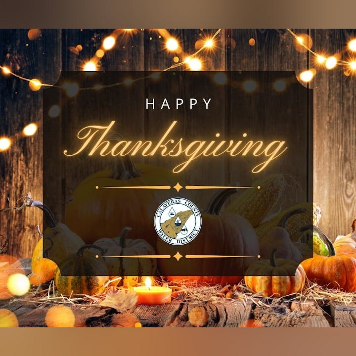 Thanksgiving message with pumpkins, corn, and warm lights, featuring Calaveras County Water District logo.