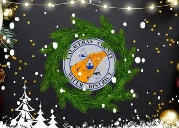 A festive wreath with a logo, surrounded by Christmas decorations, lights, and snowflakes.