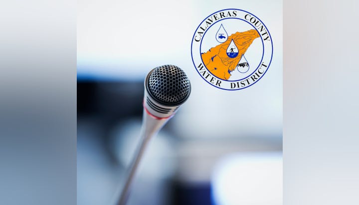 Microphone in front of a blurred logo for Calaveras County Water District.