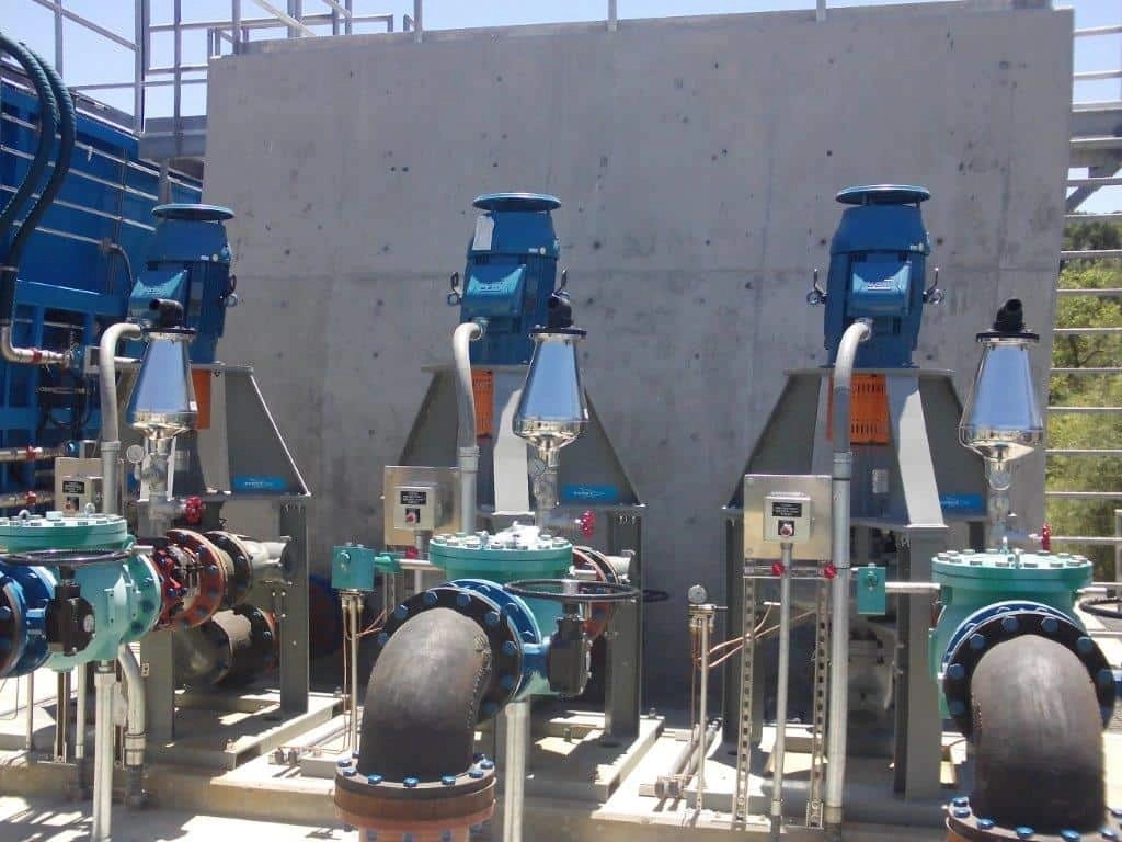 Industrial setting with pumps, valves, and piping system.