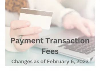A person holding a credit card near a laptop with text about changes to payment transaction fees effective February 6, 2023.