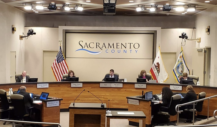 May contain: person, woman, adult, female, indoors, man, male, microphone, electrical device, courtroom, room, monitor, screen, hardware, electronics, and computer hardware
