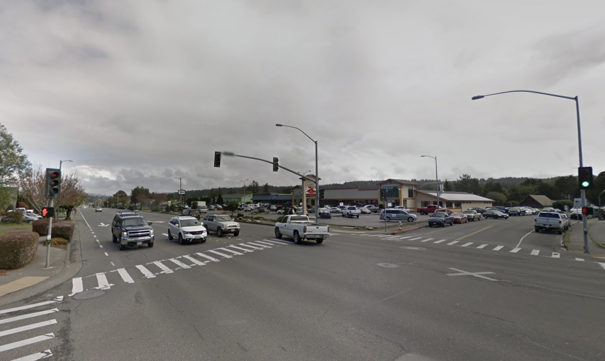 May contain: road, tarmac, intersection, traffic light, light, pickup truck, vehicle, truck, transportation, freeway, and car