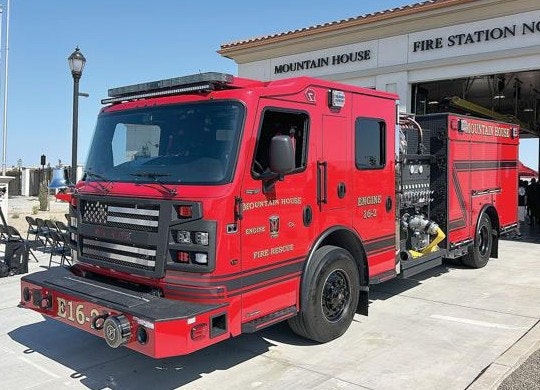 The image features a red fire truck parked outside a fire station, labeled "Mountain House Fire Rescue."