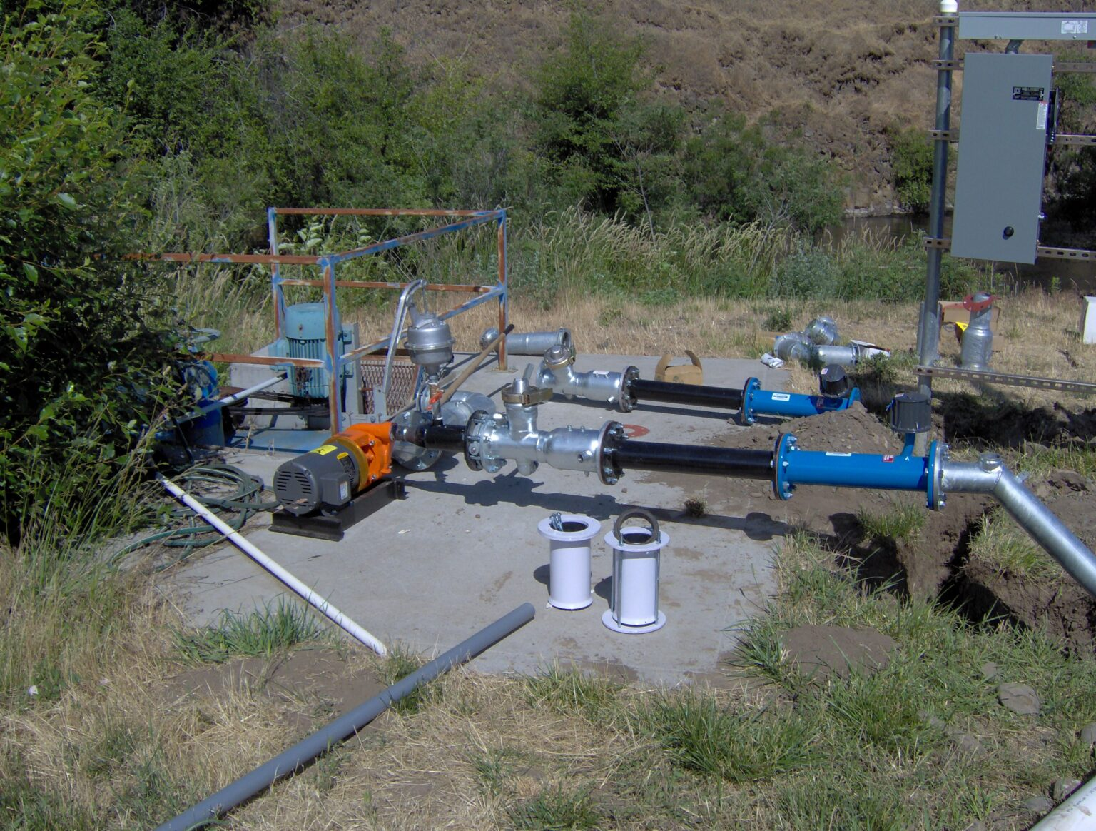 Industrial pump equipment with pipes and an electrical cabinet, possibly part of a water treatment or irrigation system.