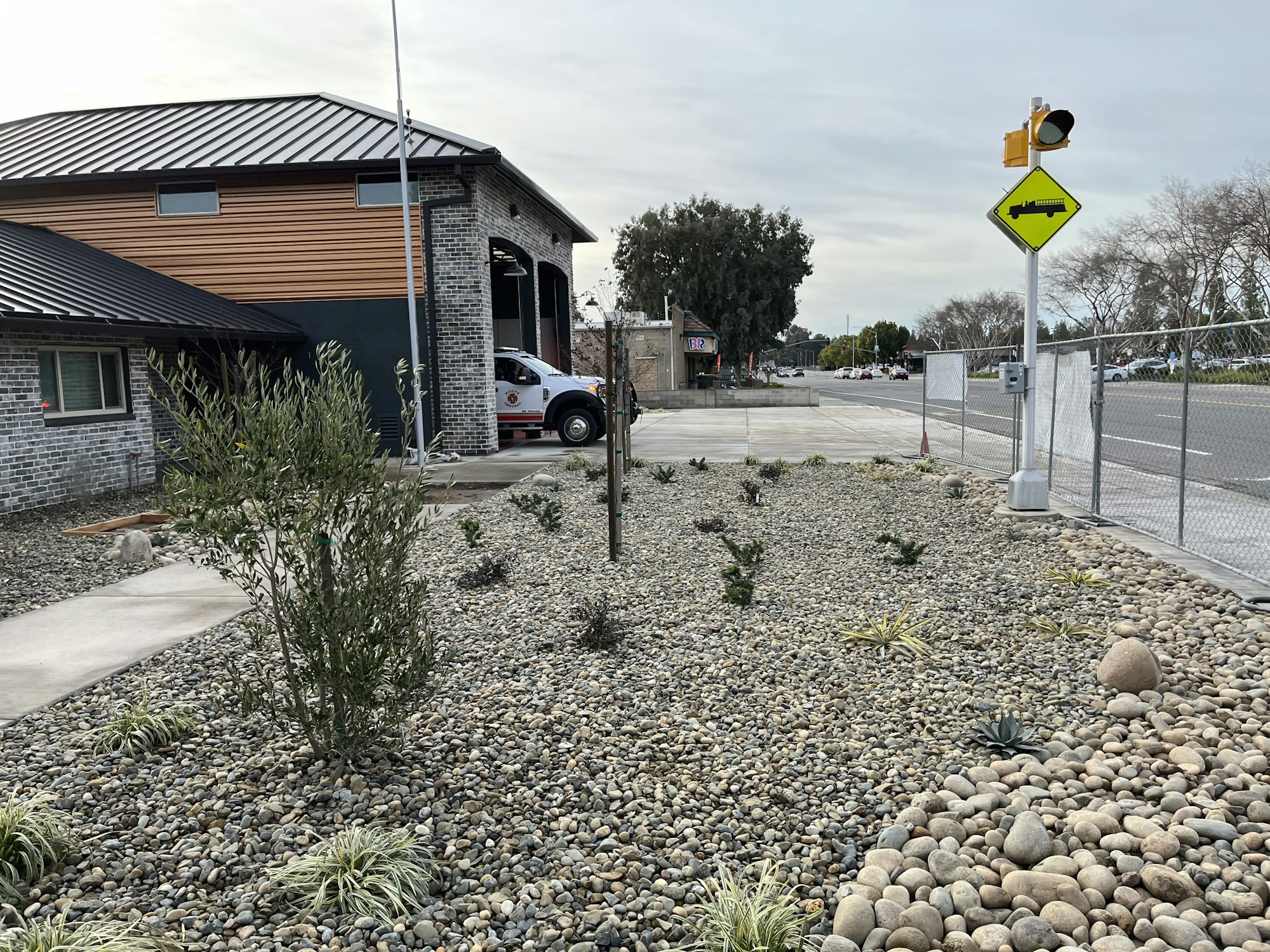 May contain: road, gravel, path, neighborhood, traffic light, light, car, vehicle, transportation, city, shelter, outdoors, building, and architecture