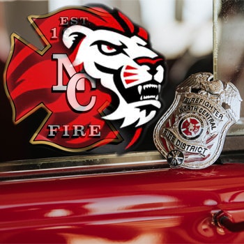 Badge reading "Firefighter North Central Fire District" and a logo featuring a lion's head with "NC Fire" and "EST 1."