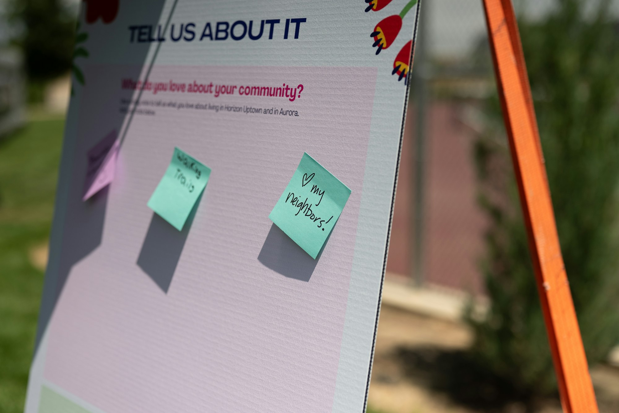 Board with sticky notes about community love; "My neighbors!" written on one.
