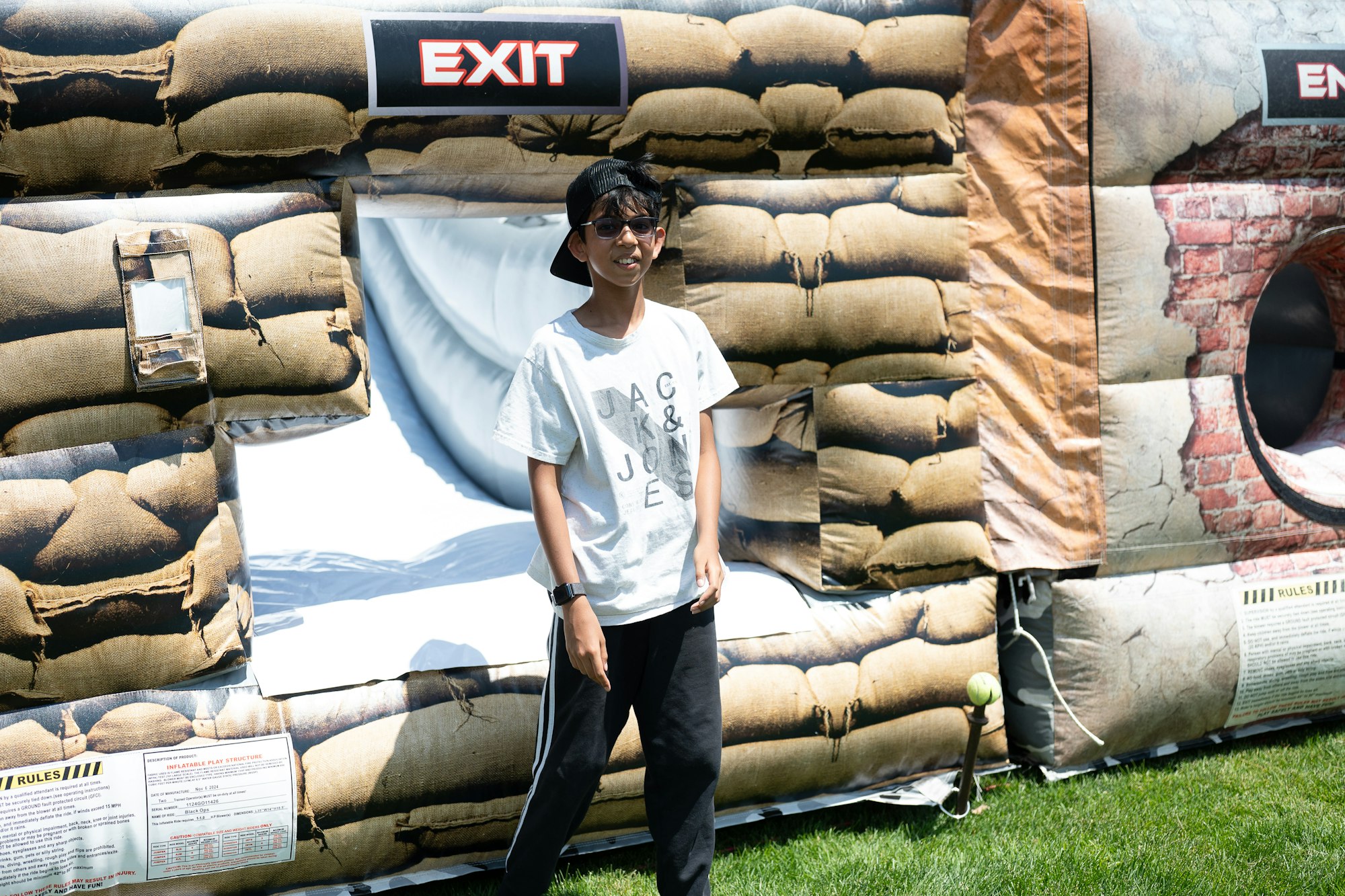 Person standing in front of an inflatable structure with a sandbag design and "EXIT" sign.