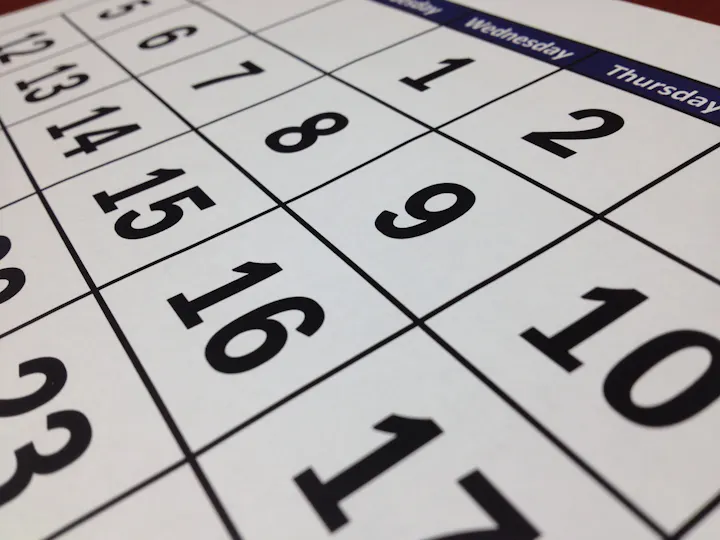 The image shows a calendar highlighting dates in a grid format, with numbers prominently displayed.