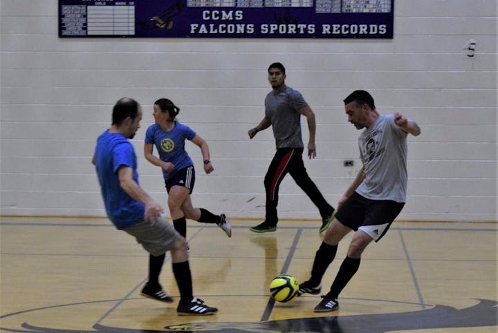 Adults playing indoor soccer
