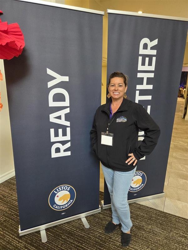 A person stands between two banners that read "READY" and "TOGETHER" with a "LISTOS CALIFORNIA" logo.