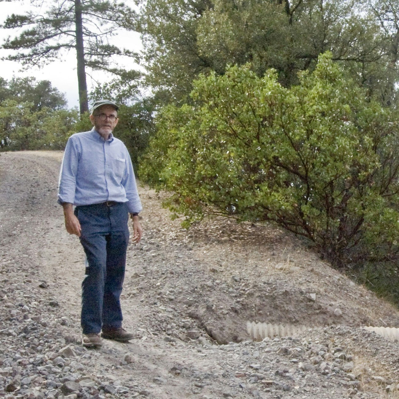 May contain: person, standing, clothing, pants, plant, vegetation, gravel, road, face, head, photography, portrait, walking, grove, land, nature, outdoors, tree, woodland, adult, male, man, jeans, path, wilderness, and shirt