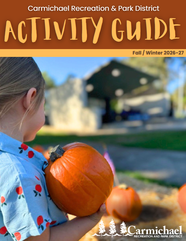A child holds a pumpkin, featured in the Carmichael Recreation & Park District's Fall/Winter 2026-27 Activity Guide.