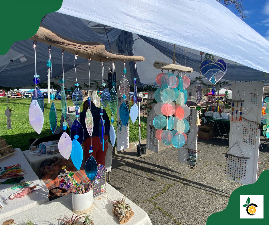 Colorful hanging glass art displayed at an outdoor market.