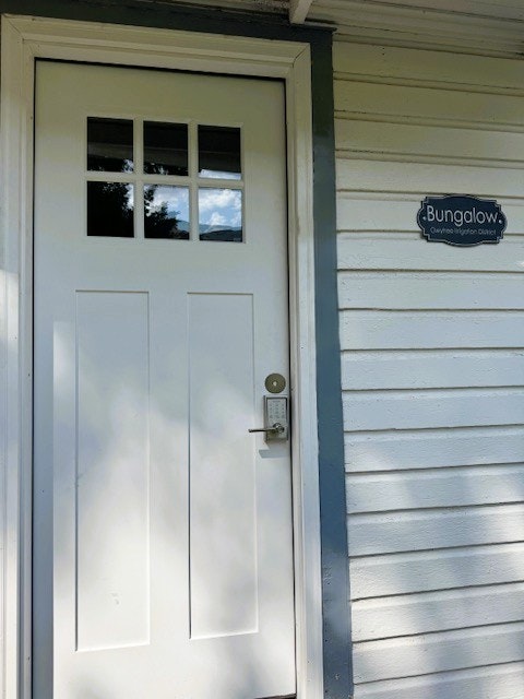 White door with a digital lock on the left and a "Bungalow" sign on the right wall.