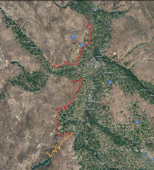 Satellite view of a landscape with marked boundaries, possibly indicating a wildfire area (red) and burned terrain (yellow).