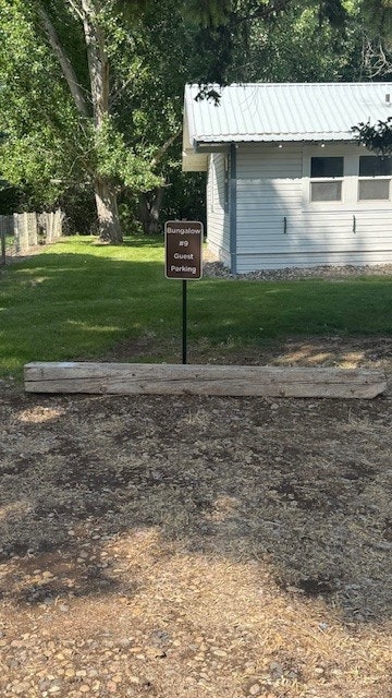 Sign for "Bungalow #9 Guest Parking" in front of a white building and green lawn, with trees in the background.