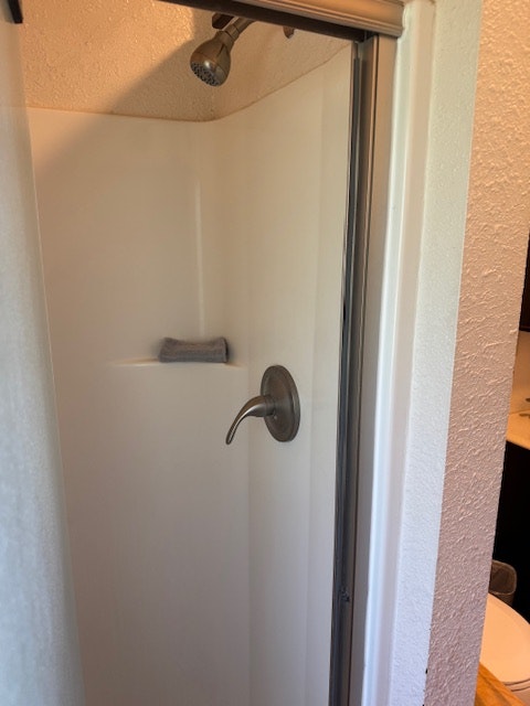 A bathtub with a metal faucet, showerhead, and a soap holder on the wall.