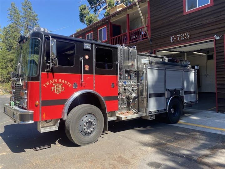 A red fire engine parked outside a building with the number 723.