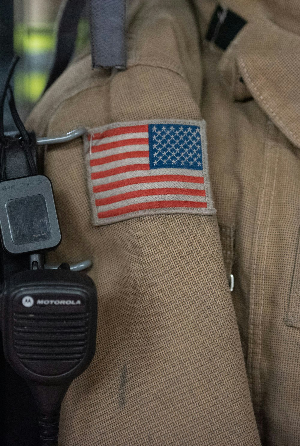 US flag patch on a uniform with a Motorola radio.