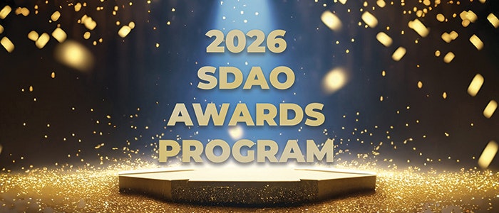 "2026 SDAO Awards Program" text on a lit stage with golden sparkles.
